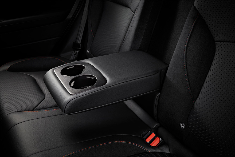 Nuleista porankė tarp galinių Subaru Forester sėdynių su integruotais puodelių laikikliais.