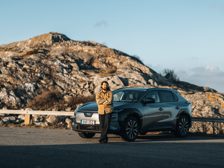 Subaru Solterra pastatytas uolėtame kraštovaizdyje su žmogumi prie automobilio.