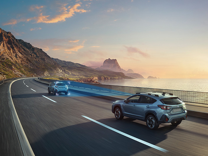 Subaru Crosstrek su EyeSight vairuotojo pagalbos sistema – mėlynas trikampis iliustruoja kamerų matymo lauką, kuris stebi kelią, siekiant užtikrinti didesnį saugumą ir saugų vairavimą.